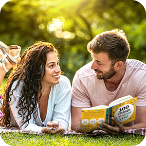 Photo of couple laying on the grass enjoying "100 Things I Love About You".